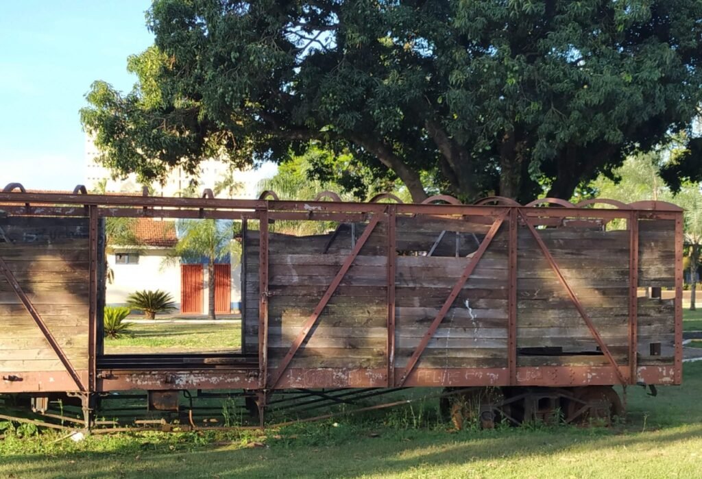 Vagão sucateado em ferrovia abandonada.